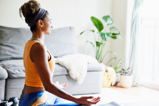 Woman meditating at home to boost immune support for cancer recovery.